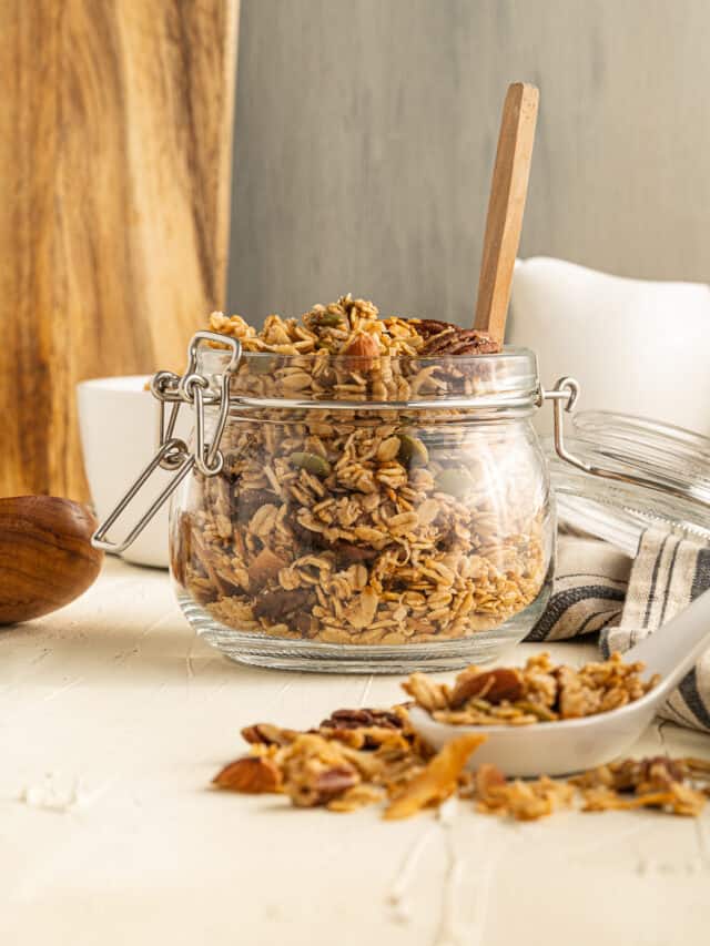 Granola in a glass jar on a wooden table.