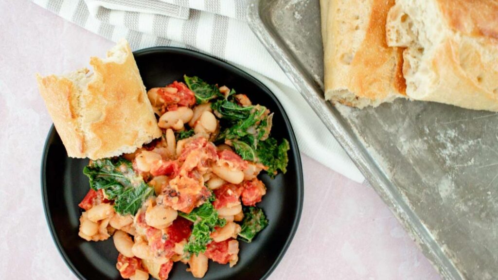Chickpeas and kale on a plate with bread.