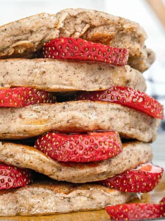 A stack of pancakes with strawberries.