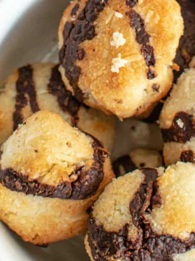 A pile of coconut macaroons with chocolate bases.