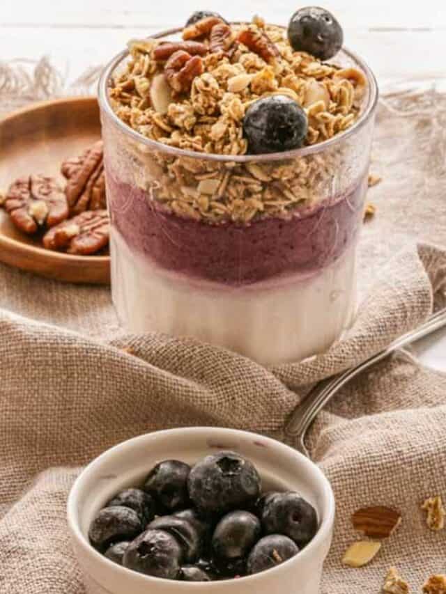 A bowl of granola with blueberries and pecans.