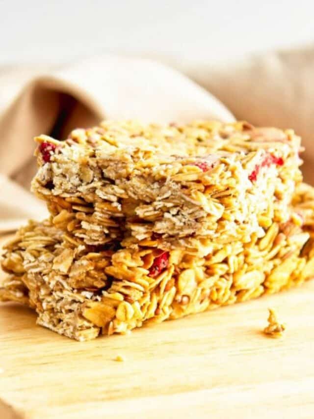 A stack of granola bars on a cutting board.