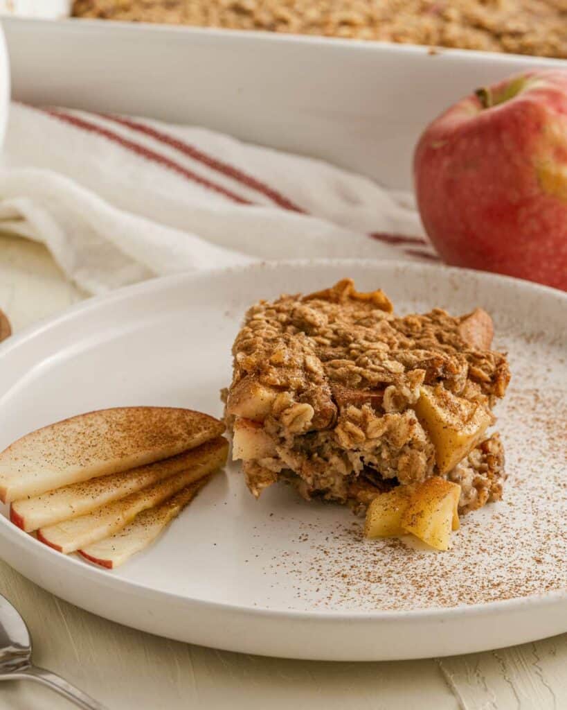 A piece of apple oatmeal on a plate with a fork.
