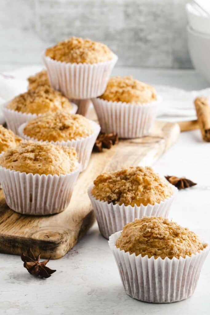 A group of muffins on a wooden board.