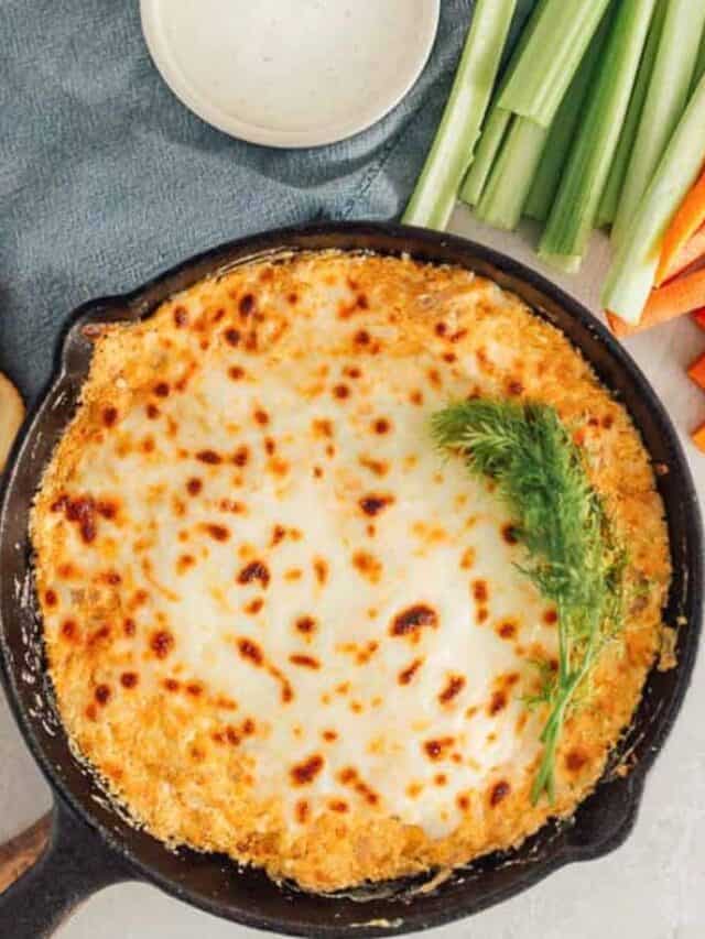 Buffalo Jackfruit dip in a skillet with carrots, celery and crackers.