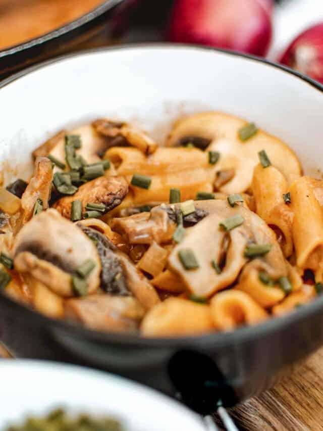 Mushroom risotto in a white bowl on a wooden table.