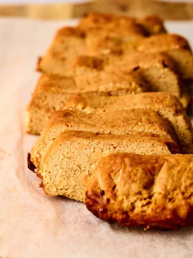 Sliced banana bread arranged on parchment paper, highlighting its moist texture and golden-brown crust.