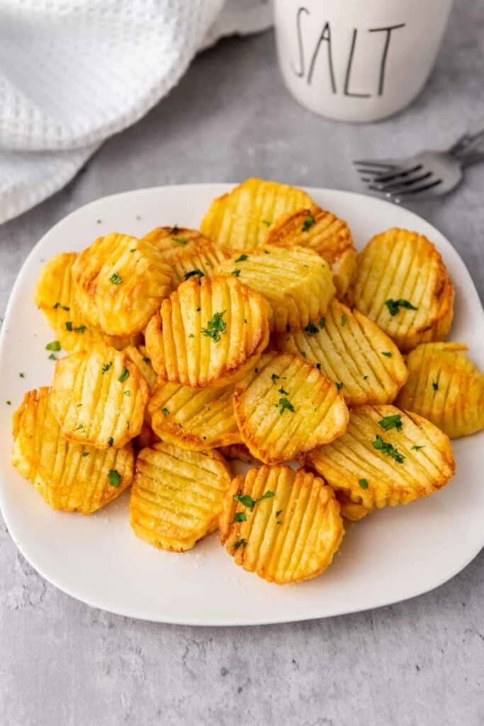 Enjoy crispy accordion potatoes cooked in an air fryer, sprinkled with salt, and served alongside a steaming cup of coffee.