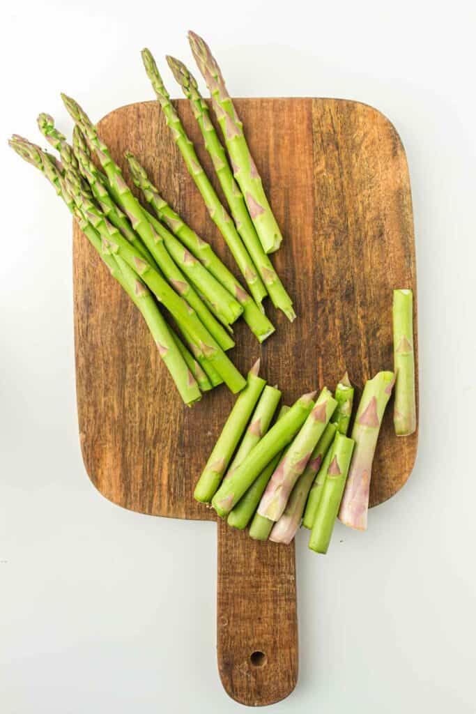 Air fryer asparagus on a wooden cutting board.