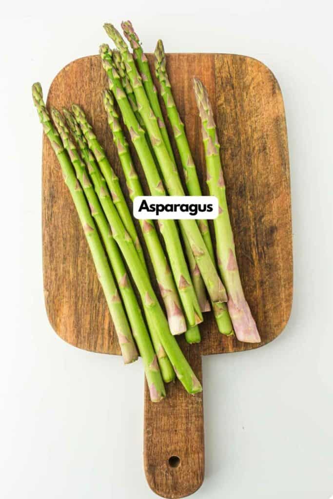 Asparagus on a wooden cutting board.