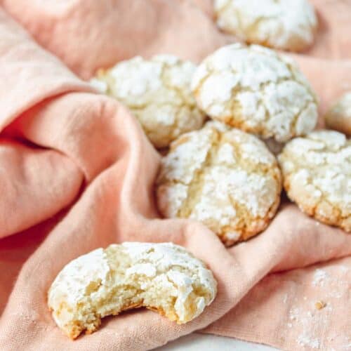 Crinkle cookies with powdered sugar on a pink towel.