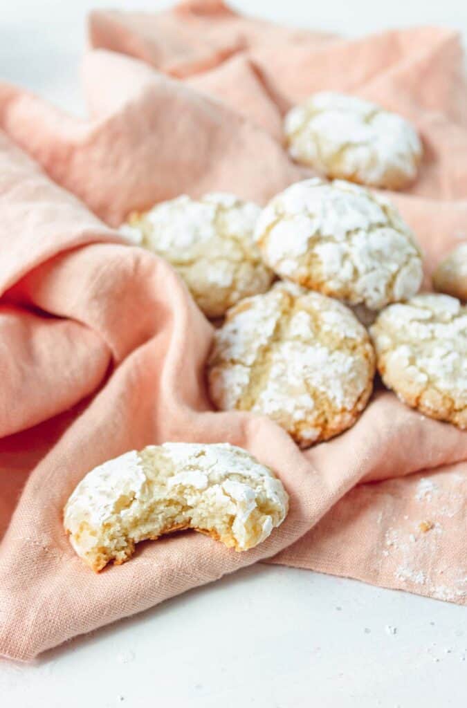 Crinkle cookies with powdered sugar on a pink towel.