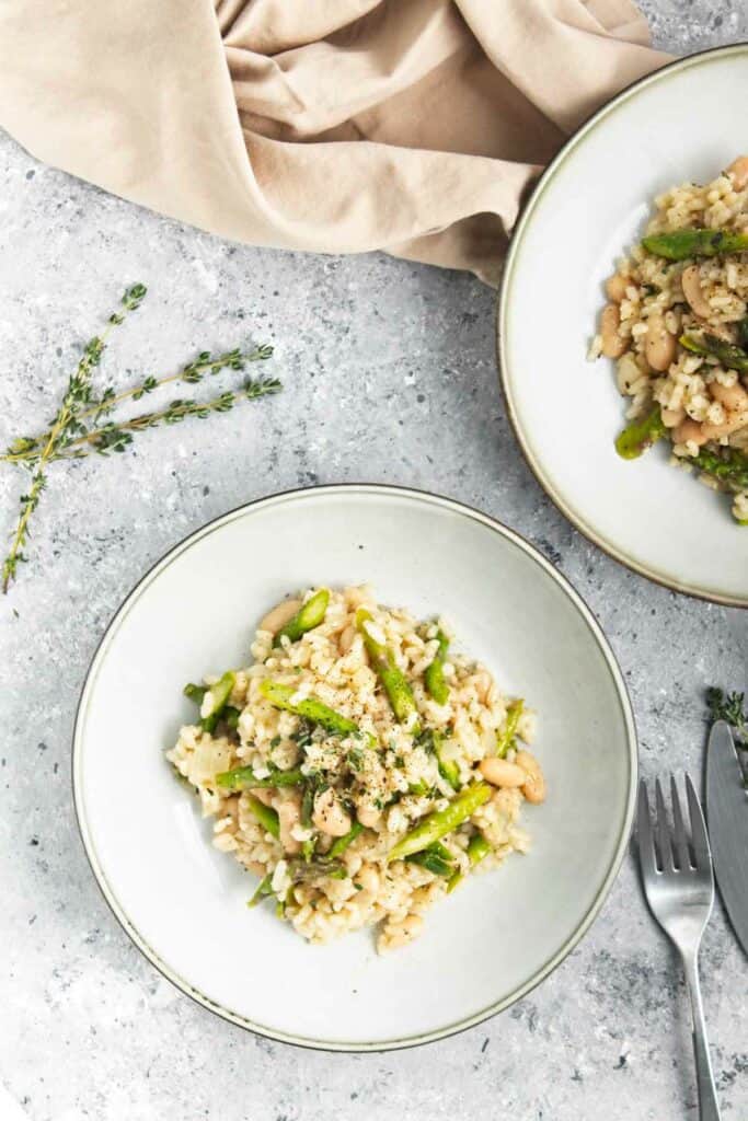 Two plates of Asparagus and White Bean Risotto with thyme.