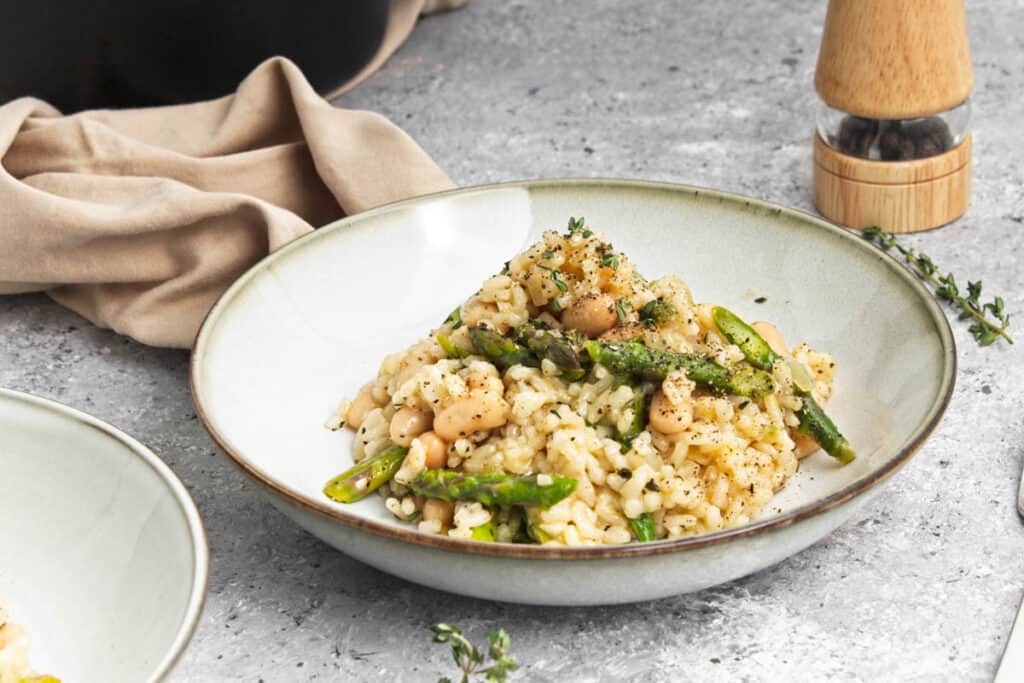 Two bowls of White Bean Risotto with asparagus and thyme.
