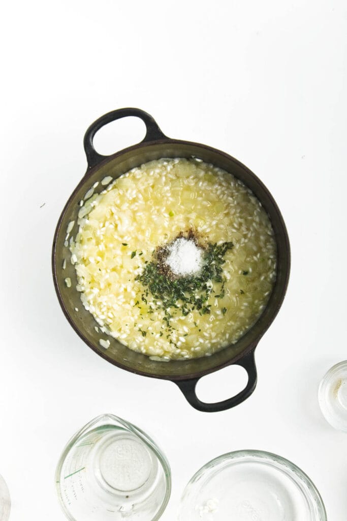 A pot with garlic, onion, and rice.