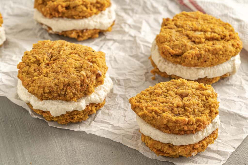 A stack of pumpkin cookies on top of a piece of paper.