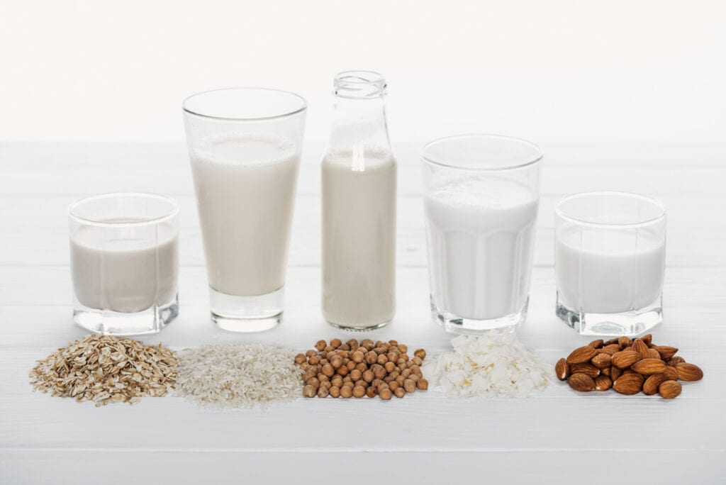 A group of glasses of milk and a group of nuts.