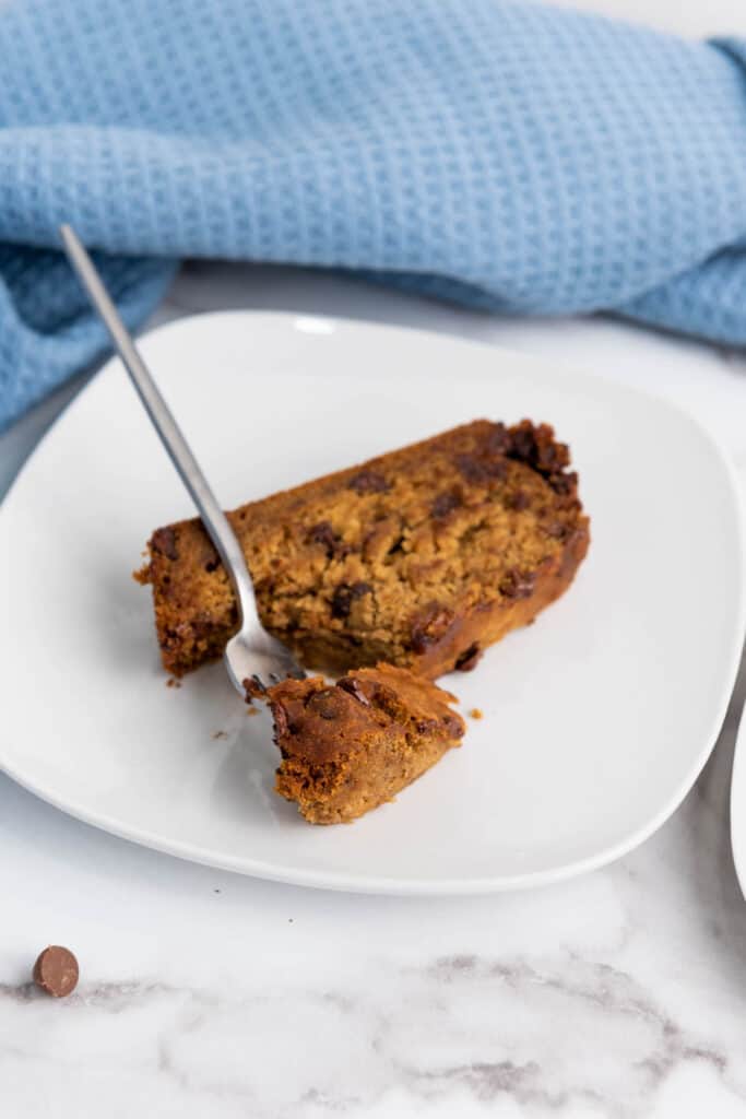 A slice of gluten-free banana chocolate cake on a plate with a fork.