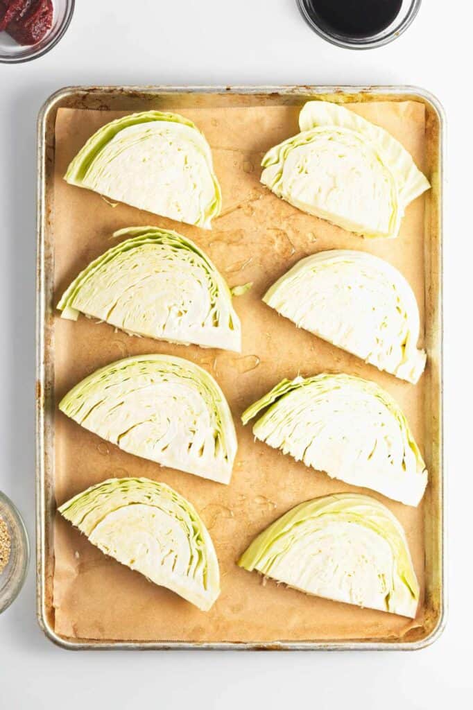 Sliced cabbage and gochujang on a baking sheet.