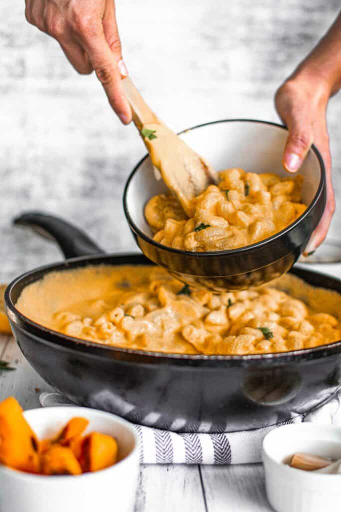 Macaroni and cheese in a skillet with carrots.