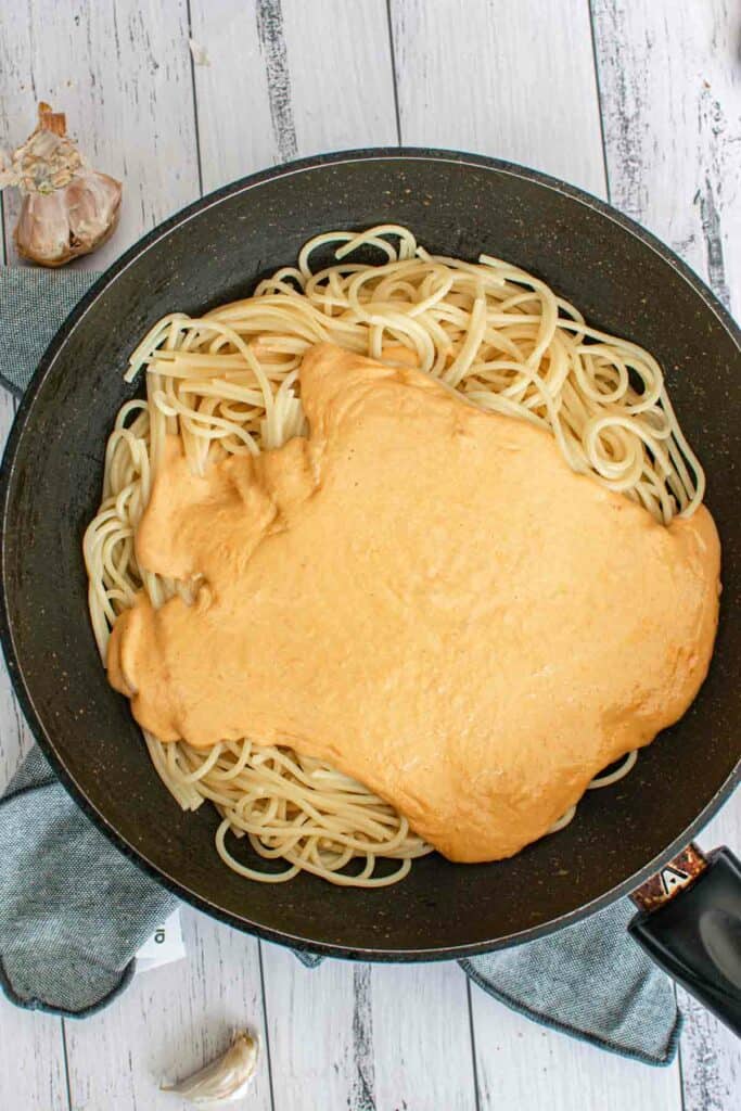 A frying pan filled with pasta and sauce.