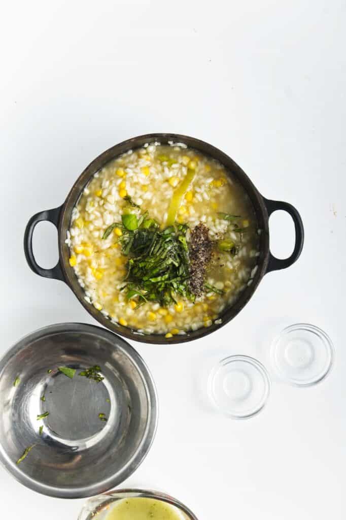 A bowl of sweet corn and leek risotto with herbs.