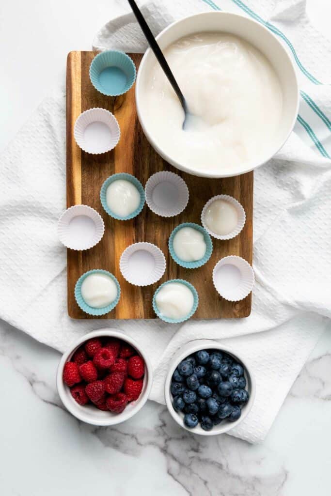 A bowl of yogurt and mini cupcake liners.