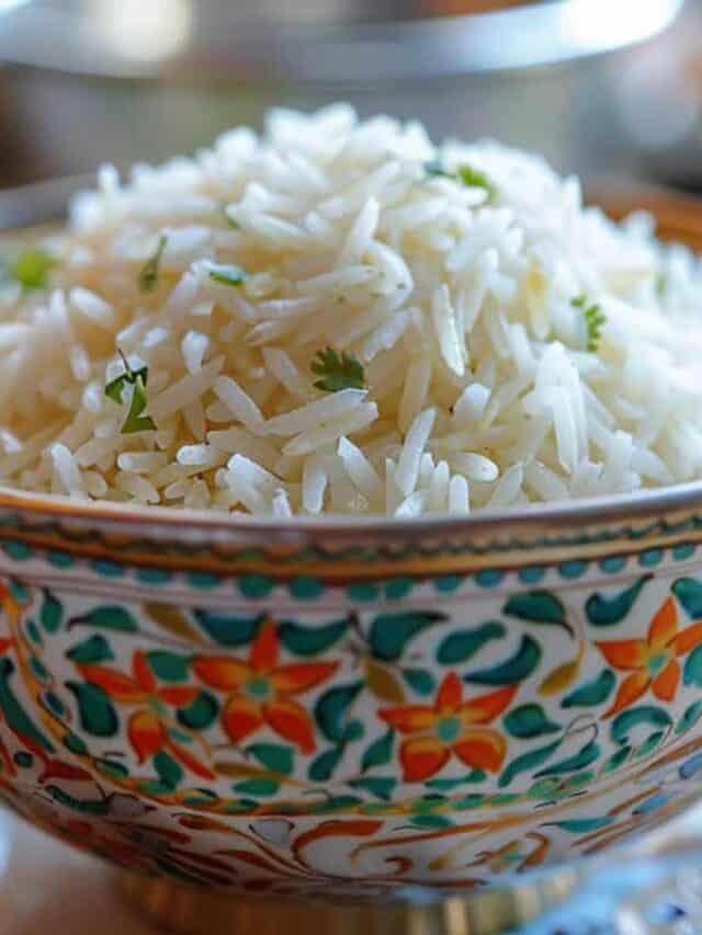 A bowl of cooked white rice garnished with herbs.