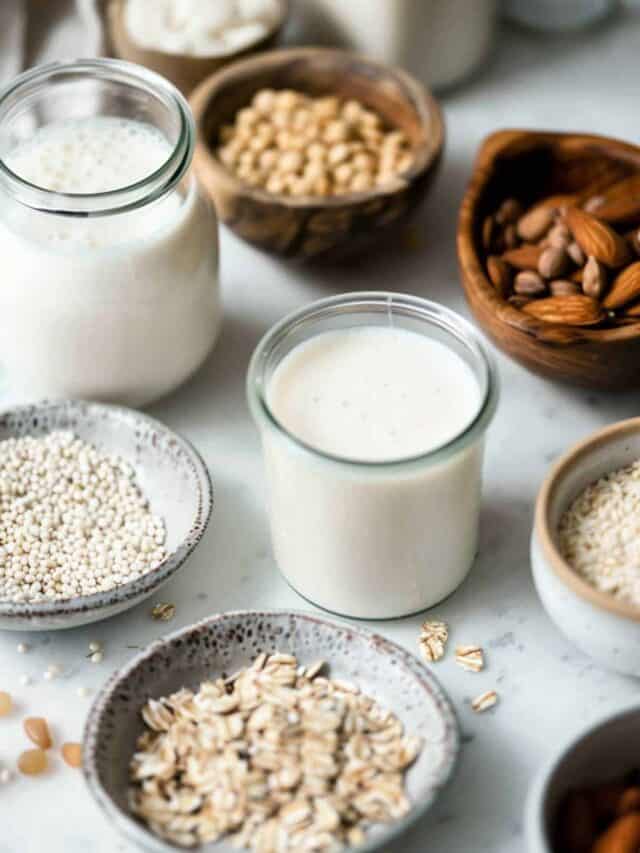 Oats, almonds, milk and other foods in bowls on a table.
