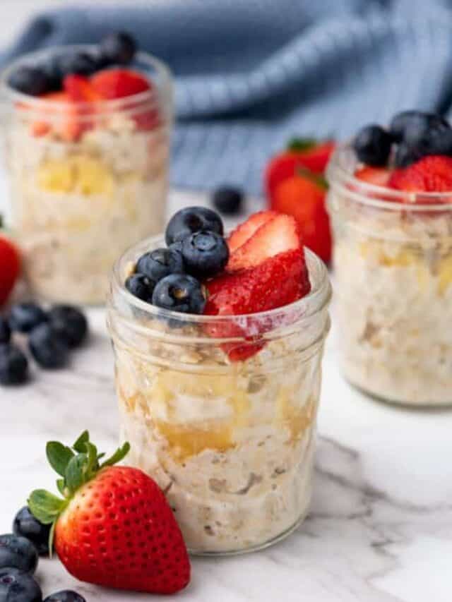 Three jars of overnight oats with berries and blueberries.