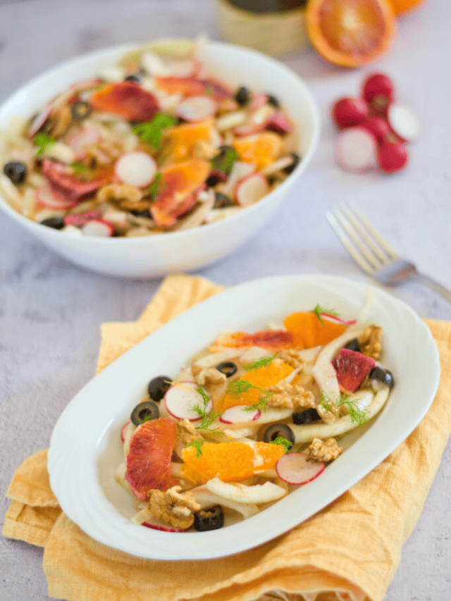 A colorful citrus salad with figs, radishes, and olives served on a white plate and bowl.