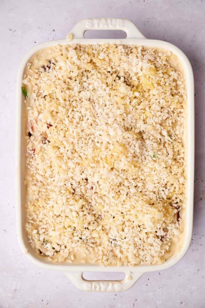 A rectangular baking dish filled with an uncooked Air Fryer Vegan Breakfast Casserole, topped with a layer of breadcrumbs and ready to be baked.