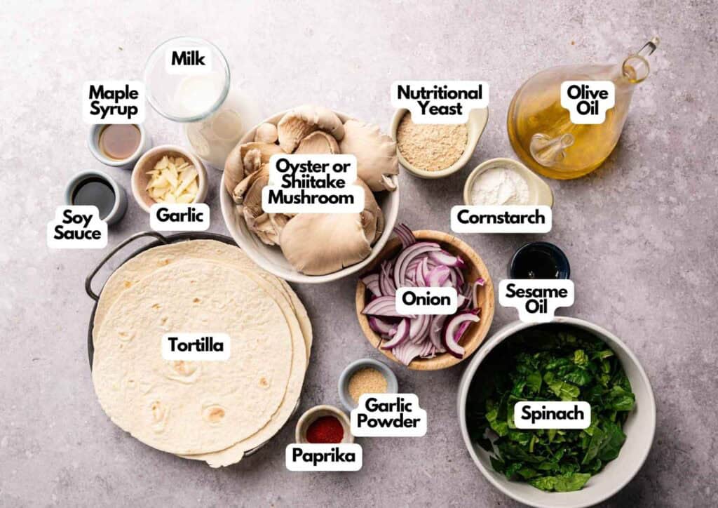 Various labeled ingredients for Vegan Quesadillas with Mushroom Bacon, including tortillas, oyster or shiitake mushrooms, spinach, onion, garlic, milk, nutritional yeast, cornstarch, olive oil, sesame oil, maple syrup, soy sauce, paprika, and garlic powder.